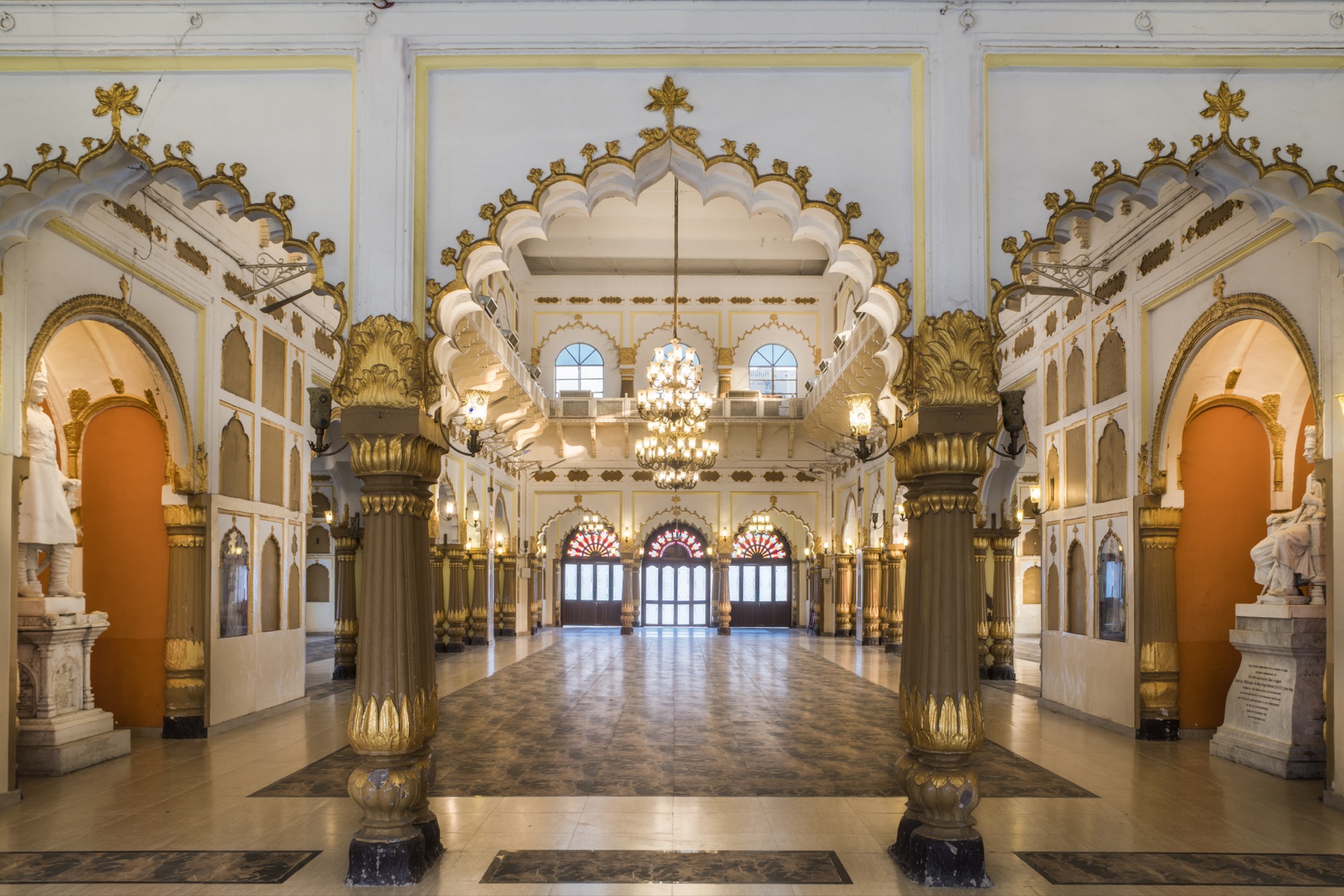 Ornate interior with orange arches and marble statues